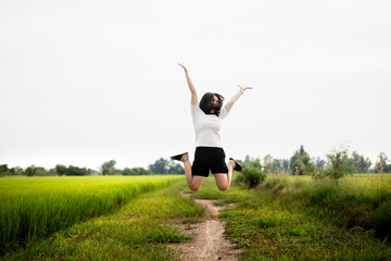 Fototapeta premium Beautiful Asian young woman enjoy running and relaxing at the rice field - meadow. 