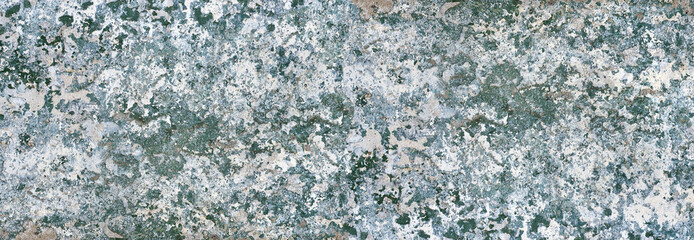 motley damaged stucco wall with cracks and peeling paint flakes