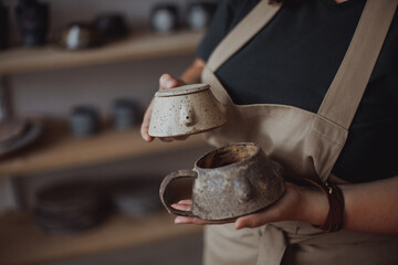 Obraz premium Middle-aged plus-sized woman in a pottery workshop with her eco-friendly clay utensils