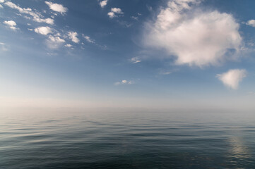 Naklejka na ściany i meble blue sky and clouds are reflected in the serene lake water