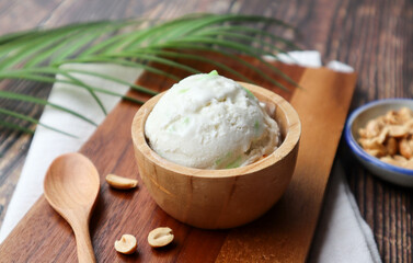 Scoop of coconut milk ice cream in wood bowl - close up view of Thai famous dessert