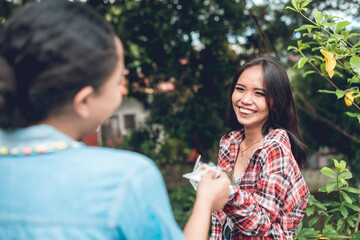 A young woman happily accepts a cash donation from her friend. Grassroots fund raising campaign.
