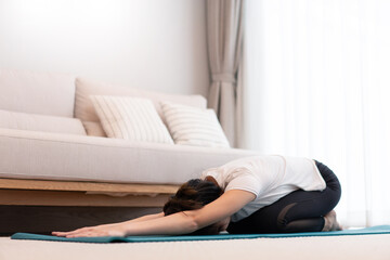 Productive activity concept in the living room a girl bending the body parallel to the floor on the green yoga mat willingly