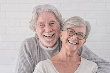 Beautiful happy couple of two senior people hugging each other - standing having fun at home - serene retirement concept