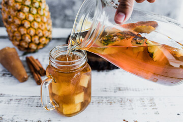 Tepache mexican Fermented pineapple drink and hand holding a Jar with kombucha homemade probiotic...