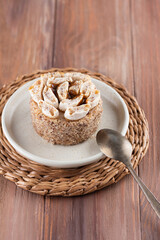 Delicious cake with nuts in a plate on a wooden table.