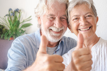 Beautiful senior couple  looking at camera gesturing positive sign. Serene elderly people enjoying retirement