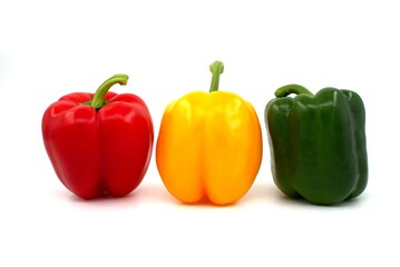 Red green and yellow bell peppers on white background