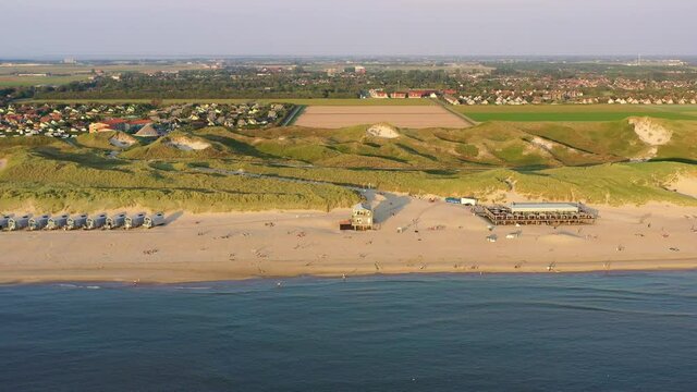 Drohnenaufnahme, Luftaufnahme, Flug entlang der K&uuml;ste von Julianadorp aan Zee an der Nordsee mit Blick auf Ferienh&auml;user direkt am Strand, die D&uuml;ne und die Landschaft dahinter, Den Helder, Nordholland,