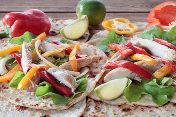 Chicken fajitas with grilled onions and bell peppers and tortillas. Selective focus.