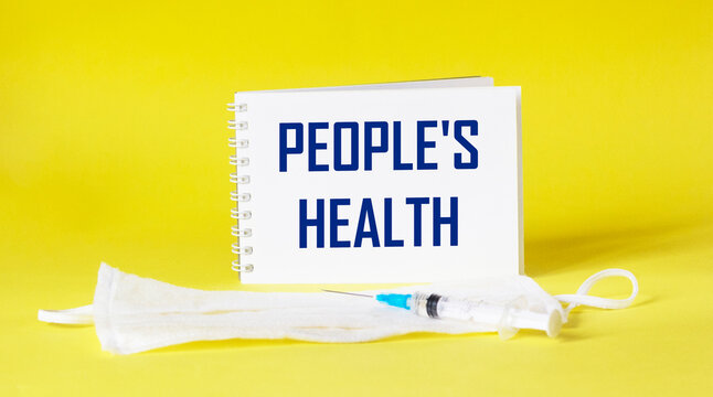 On a yellow background, a medical mask, a vaccine and a notebook with the inscription PEOPLES HEALTH. - Powered by Adobe