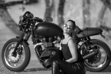 Plakat young woman on a black motorcycle