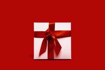 One white gift box red ribbon on red background. different size. Merry Christmas and Happy New Year gift shopping and sale concept. St Valentines Day or birthday gift. Minimal edgeless