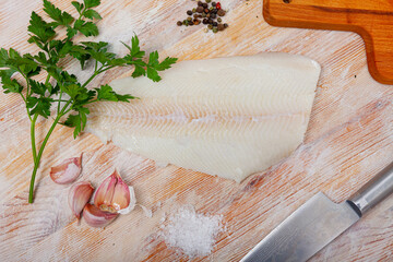 Fresh raw fillet of halibut fish on wooden background