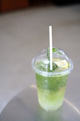 Iced matcha lemon soda on the table, Pouring green tea into a glass of honey lemon soda.