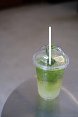Iced matcha lemon soda on the table, Pouring green tea into a glass of honey lemon soda.