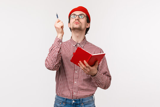 Waist-up Portrait Of Funny Male Scientist Working On Project, Passionatly Look Up And Raise Pen As Have Perfect Idea, Holding Notebook, Writing Down His Inspiring Thoughts, Stand White Background