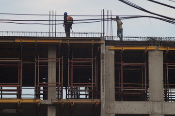 Full-color horizontal photo. An illustration of the work of the construction industry. Parts of buildings under construction in bad weather. To criticize or describe the difficulties of the profession