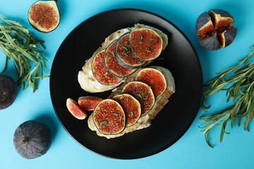 Plate with bruschetta with fig on blue background