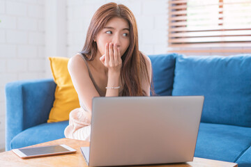 Fototapeta premium Asian woman relaxing sitting on sofa using computer notbeook at living room, Education technology and internet concept