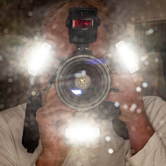 Selbstportrait des Fotografen in einem Spiegel mit drei Blitzlichtern