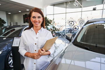 Cheerful car dealership worker ready to help you