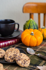 Top view of table with green plaid blanket, cookies, mug, spoon and pumpkins, selective focus, white background, vertical