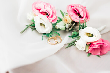 Beautiful toned picture with wedding rings against the background of a bouquet of flowers