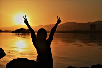 Fototapeta premium silhouette photography capturing girl having fun moments on lake site