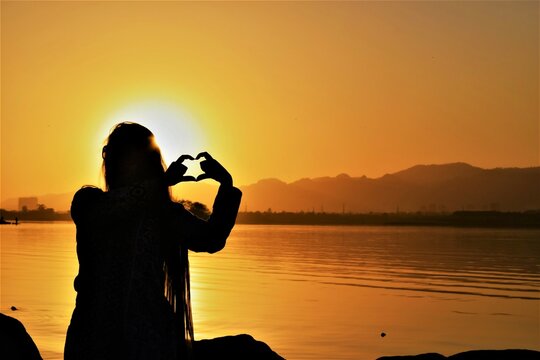 silhouette photography capturing girl having fun moments on lake site