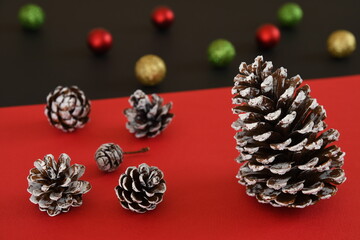 Christmas pinecones on red and black background.