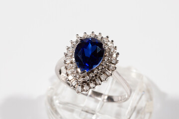 Diamond ring. Diamond ring with sapphire on white background. Ring with diamonds and large sapphire. Golden wedding rings.