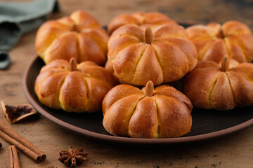 Pumpkin buns bread with spices on brown background. Halloween Food Concept. Autumn concept.