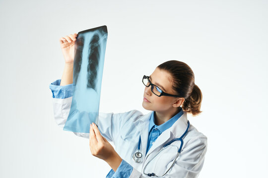 a nurse in a white coat looking at an x-ray Professional examination