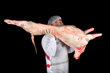 Butcher carrying lamb carcass. Professional male butcher cutting lamb carcass in butcher shop Raw...