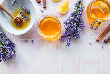 Jars and bowl with honey and fresh lavender flowers