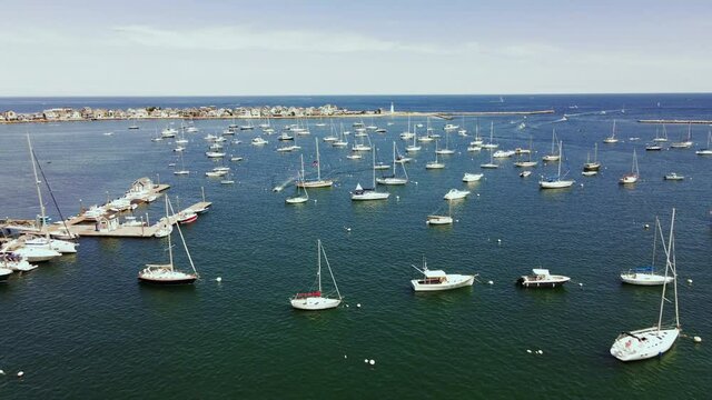 Aerial Footage of Scituate Harbor, Low Long Pullback with drone, showing moored yachts, open ocean in distance