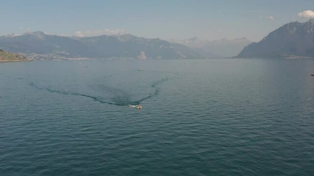 Beautiful aerial of small motorboat driving over lake Geneva