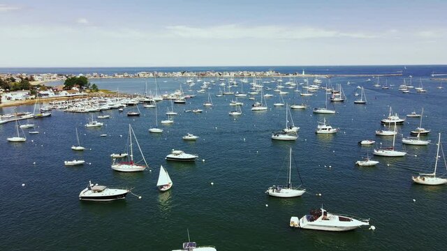 Drone footage of Scituate Harbor in MA, Low long push forward showing multiple boat and yachts.  Atlantic Ocean in Distance