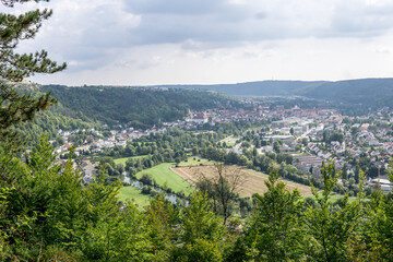 Fototapeta na wymiar panoramic view over little city in a valley surrounded by hills in germany