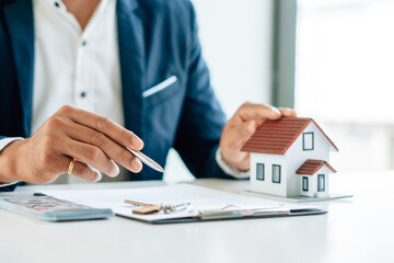 The real estate agent is explaining the house style to the clients who come to contact to see the...