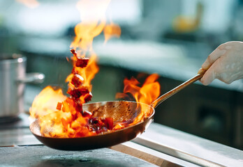 Modern kitchen. Cooks prepare meals on the stove in the kitchen of the restaurant or hotel. The fire in the kitchen.