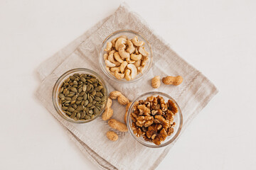 Nuts and vinegar on a linen tea towel on a white table. Walnuts, cashews and pumpkin seeds for proper nutrition. healthy foods and nutrients for the brain and body