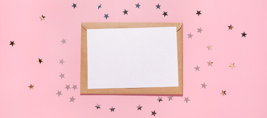 Empty card and confetti stars pours on a pastel pink background, top view. Flat lay. Holiday, greeting or good news concept. Mockup template. top view. Blank flyer