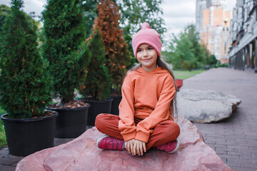 School girl in trendy hats and hoodie having fun in the park, fall vibes, autumn beauty style,...