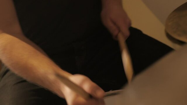 Drum kit getting played by a musician in a close-up.