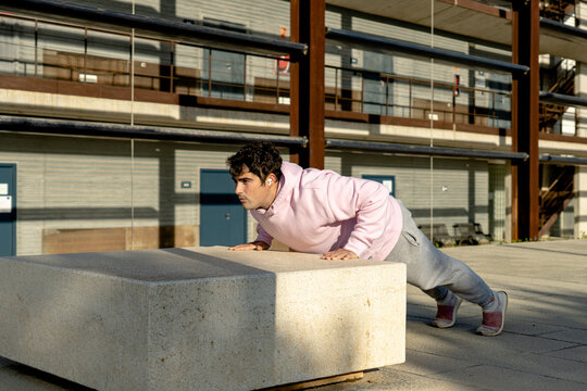 fat man doing push-ups in sportswear and listening to music