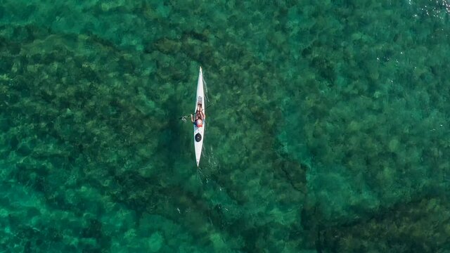 Single seat canoe rowing over a shallow lagoon, Aerial view.

