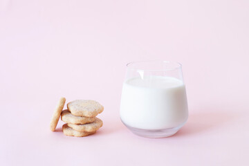 Cookies and glass of milk in pink background