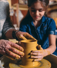 Pottery workshop. Grandpa teaches granddaughter pottery. Clay modeling